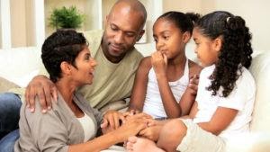 A mother and father talking and comforting their two children