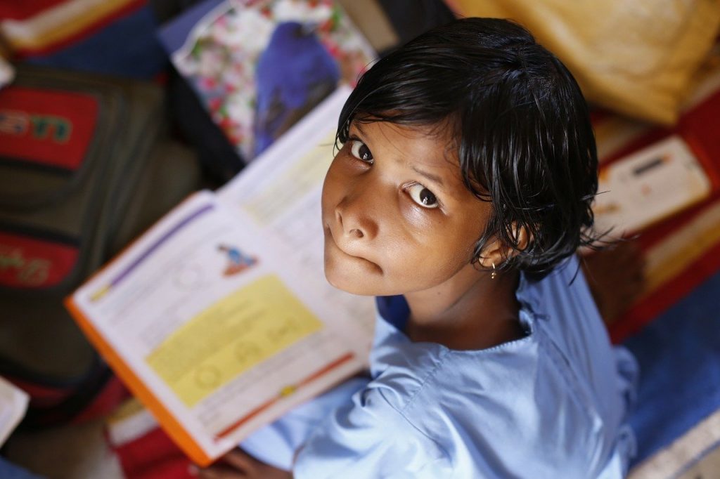 Image of a girl at school reading a book.