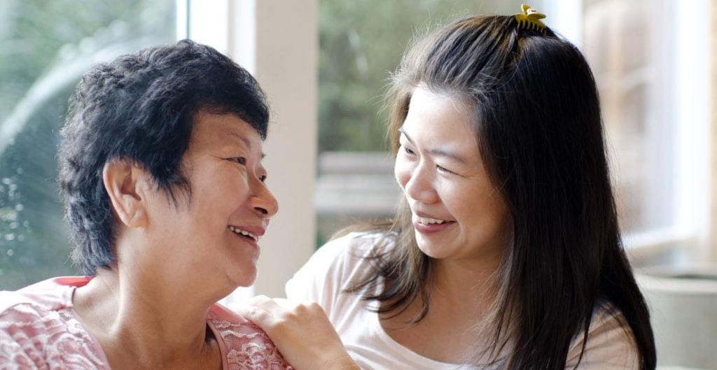 An individual smiling next to their carer