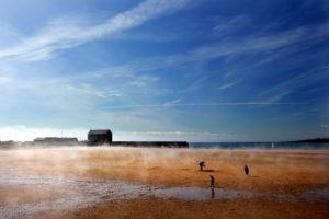 A seaside scene with people walking on the beach