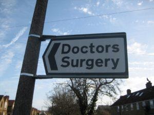 A sign directing to a doctors surgery