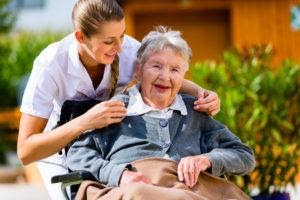 A healthcare assistant comforting an elderly patient