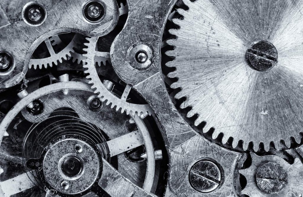 A black and white photo of a series of metal cogs and springs.