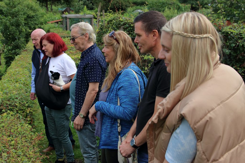 Group of people on a mindful walk looking at a garden.