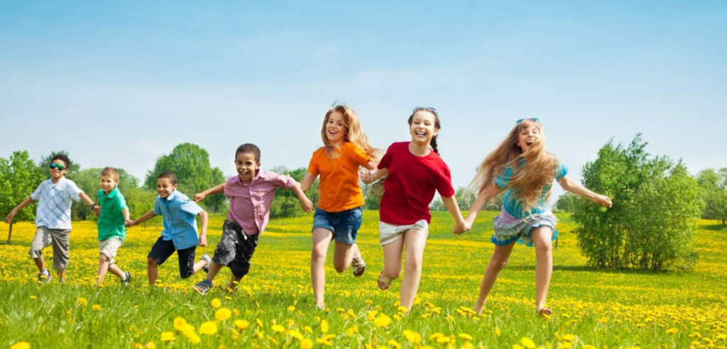 A group of children running through a field.