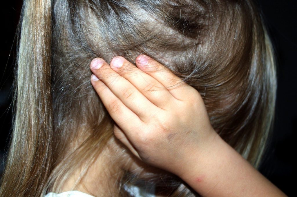 Image of a child covering their ears.