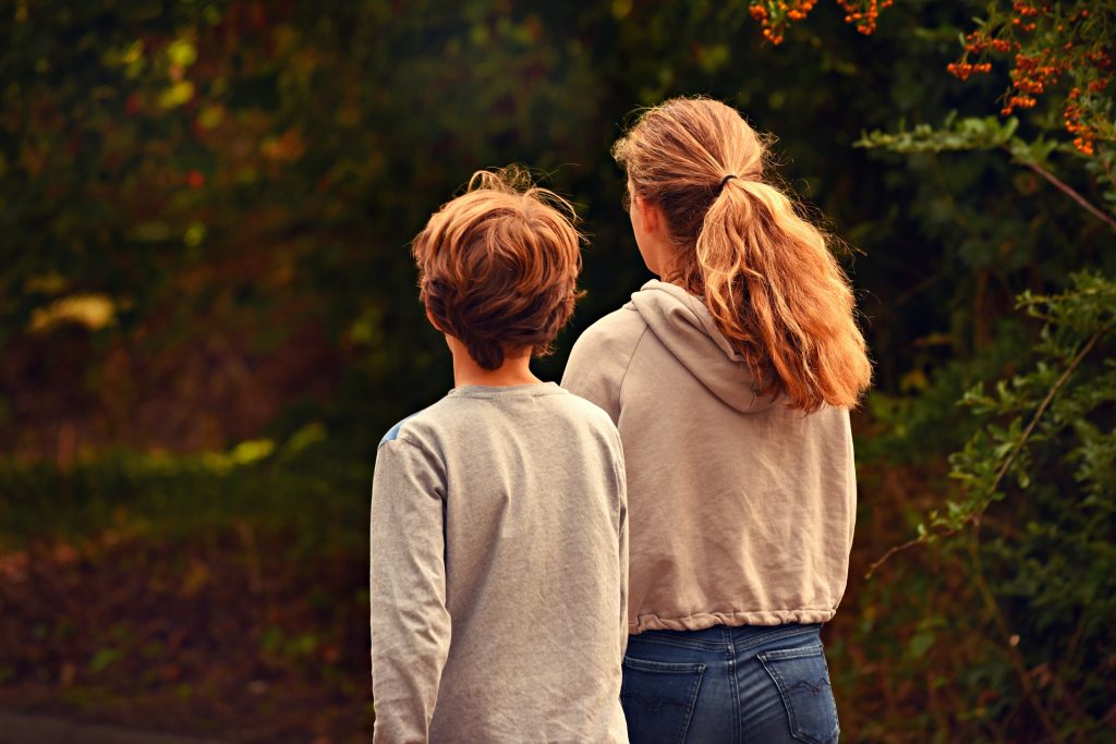 Image of two siblings (male and female) walking together.