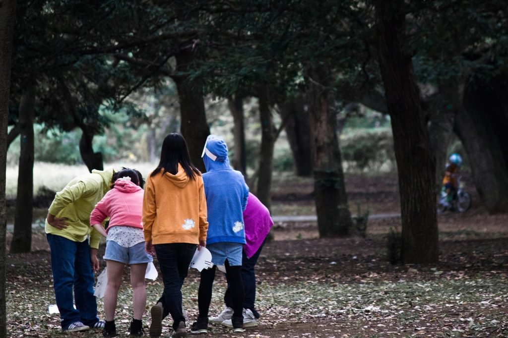 A group of teenagers in the park socialising.