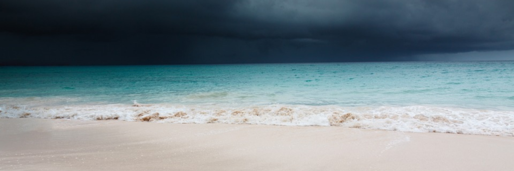 sunny beach, turquoise seas, dark clouds