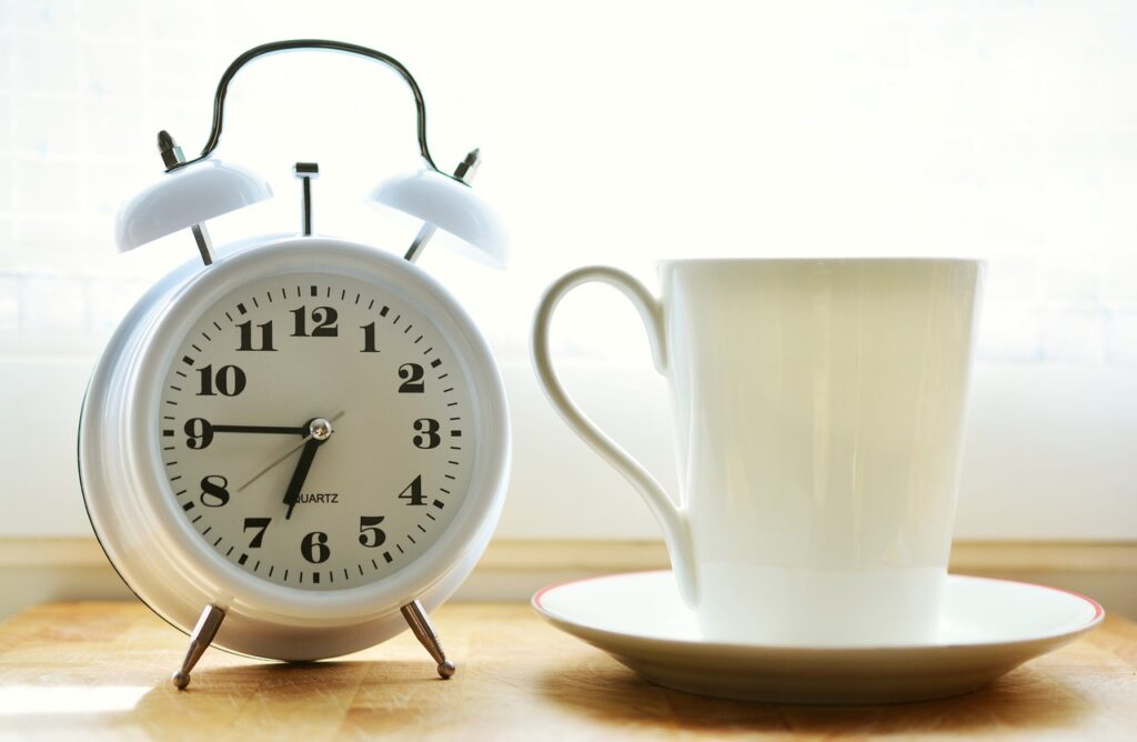an alarm clock and a coffee cup.