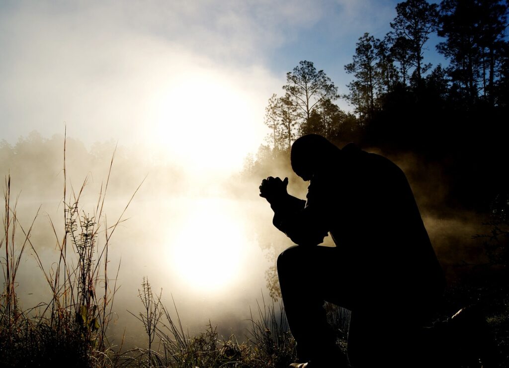 A person trying to pray surrounded by fog.