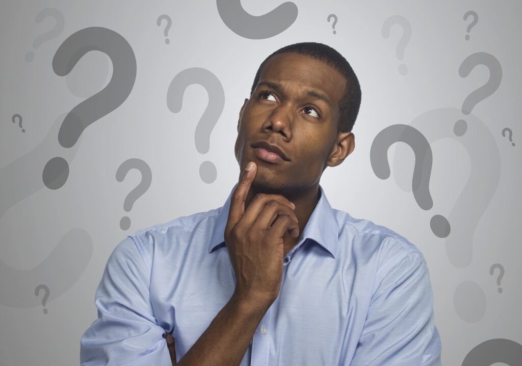 A person thinking surrounded by question marks.