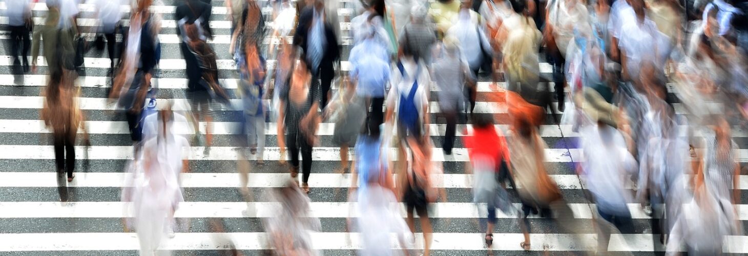 Lots of people walking down some steps. They are blurry resembling fast movement.