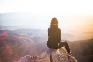 a woman sitting on top of a mountain