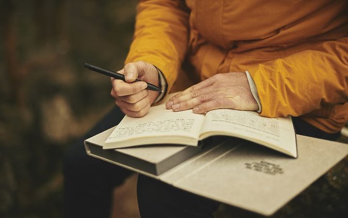 a man writing in a notebook