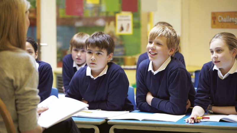 teacher reading to pupils in a classroom.